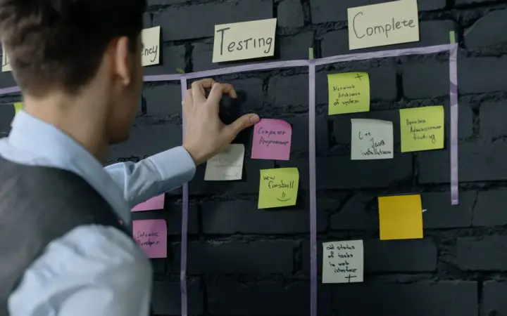 Personne organisant un flux de travail avec des notes adhésives