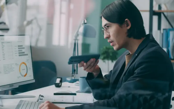 Analyste examinant des graphiques de performance sur un écran dans un bureau