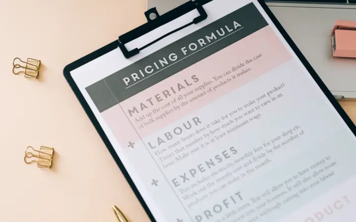 Fiche de calcul des coûts sur un bureau avec ordinateur portable et fournitures