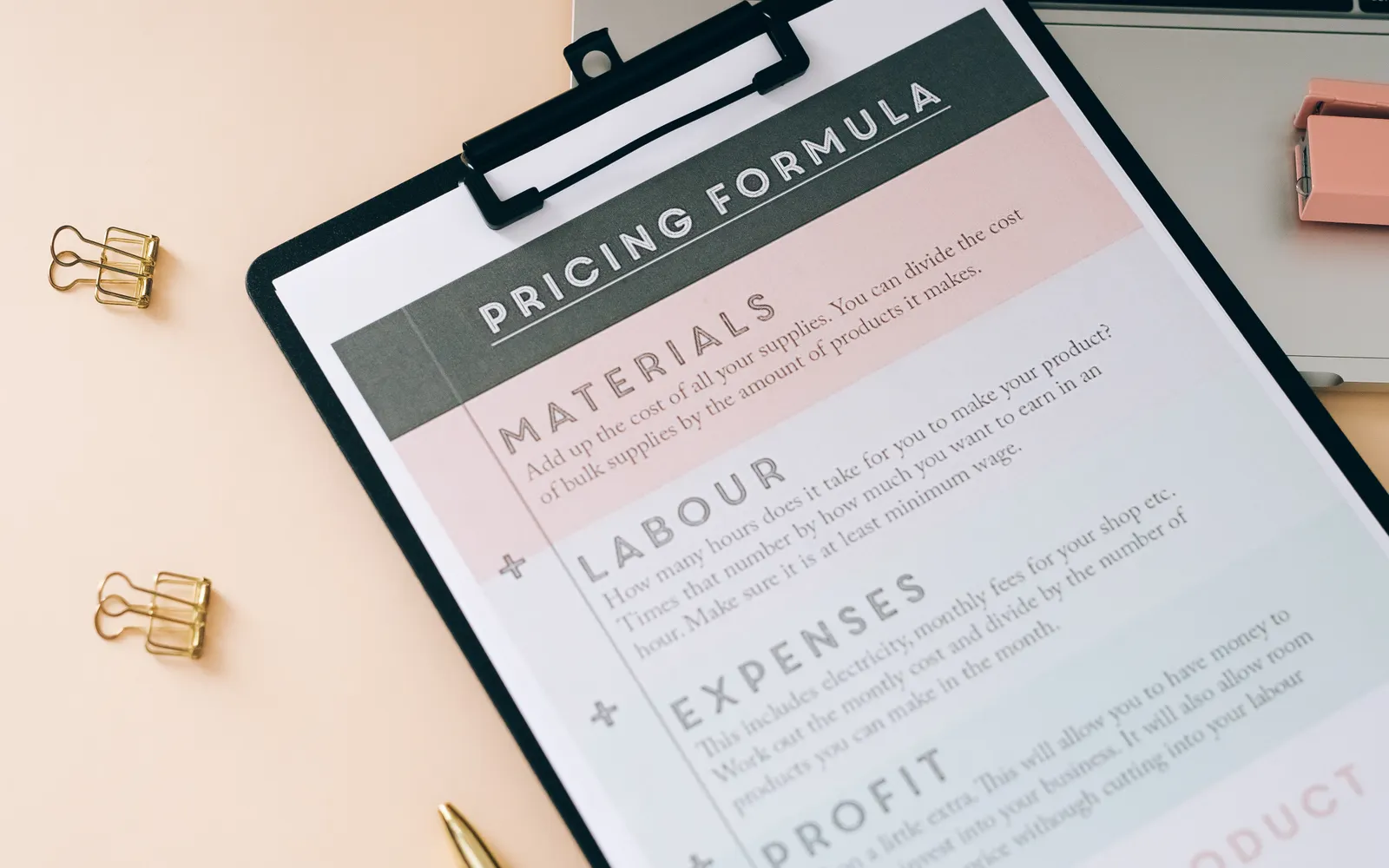 Fiche de calcul des coûts sur un bureau avec ordinateur portable et fournitures