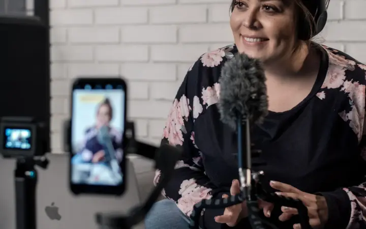 Créatrice enregistrant une vidéo avec caméra, smartphone et microphone