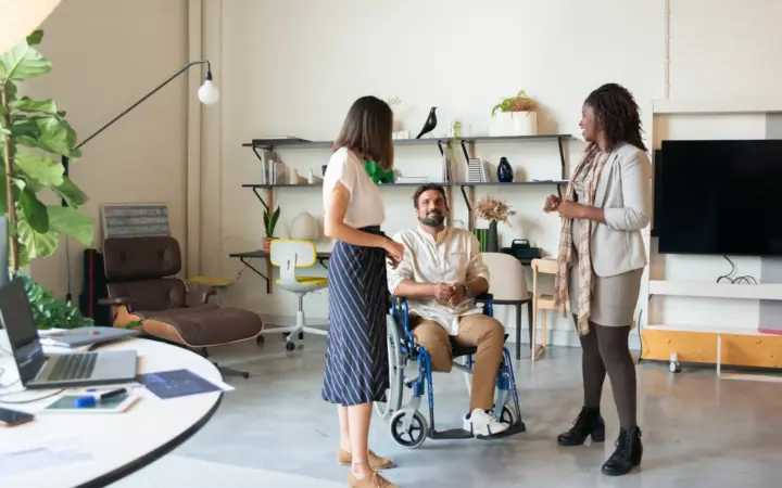 Équipe professionnelle inclusive échangeant dans un bureau autour de différents rôles