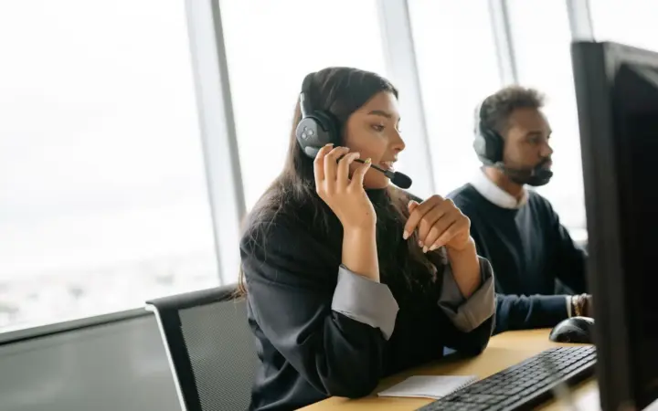 Équipe de support utilisant des casques et des ordinateurs
