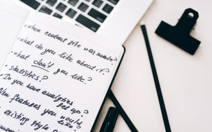 Carnet de notes ouvert à côté d’un ordinateur portable